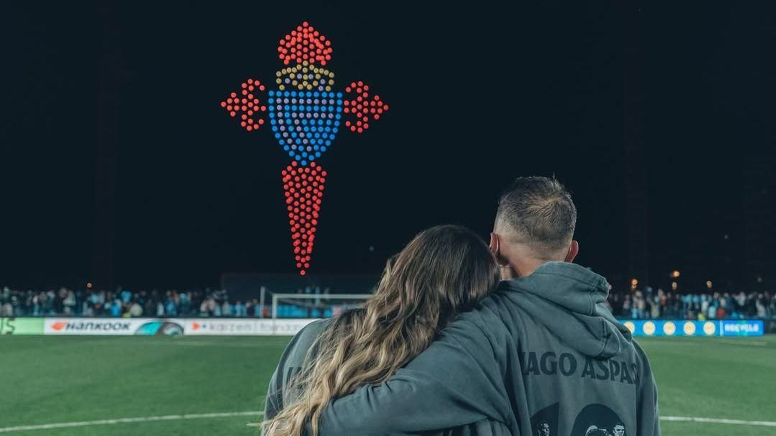 Iago Aspas e a súa dona seguen o espectáculo de drons dende o centro do campo.